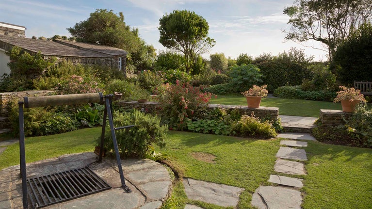 View of the garden and well to the rear of Tintagel Old Post Office, Cornwall.